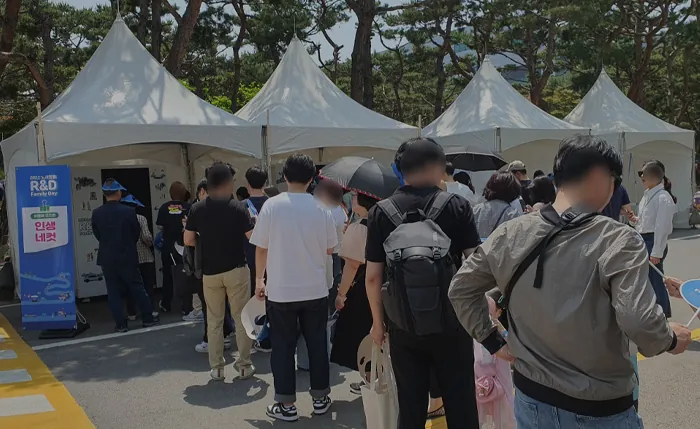 천막 부스 앞에 길게 늘어선 참가자 줄